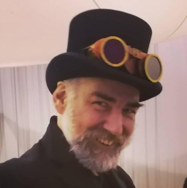 Professor Spandex - bearded man grinning in a top hat